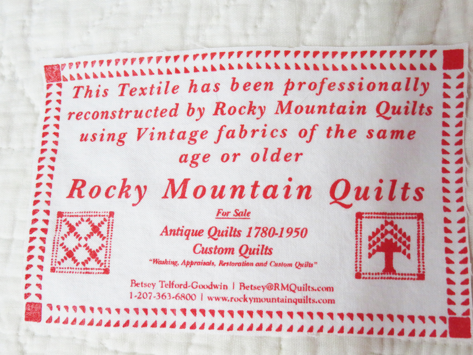 Image of the Rocky Mountain Quilts Label. Reads: This textile has been professionally restored by Rocky Mountain Quilts using Vintage fabrics of the same age or older. Rocky Mountain Quilts Antique Quilts 1780 - 1940 Betsey Telford 130 York St York, ME 03909 1-800-762-5914 www.rockymountainquilts.com